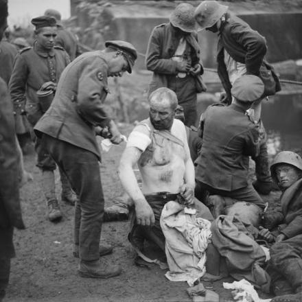 Battaglia di Broodseinde. Uomini del Royal Army Medical Corps medicano le ferite dei prigionieri, vicino a Wieltje, 5 ottobre 1917. © IWM (Q 6024)