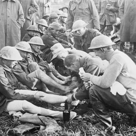Agli uomini della decima brigata australiana, che sono stati nelle trincee in prima linea per diversi giorni, vengono ispezionati i piedi alla Dragon Farm.© IWM (E(AUS) 939)