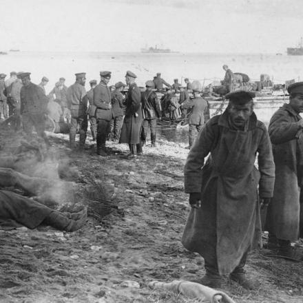 Un gruppo di prigionieri russi in primo piano mentre truppe tedesche sbarcano i loro cannoni sull'isola di Saaremaa (Osel) in Estonia, ottobre 1917. IWM Q 86793