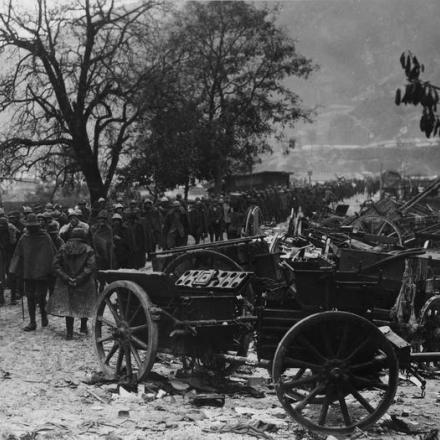 Colonna di prigionieri italiani accanto a una postazione dell'artiglieria italiana distrutta, novembre 1917. © IWM Q 86141