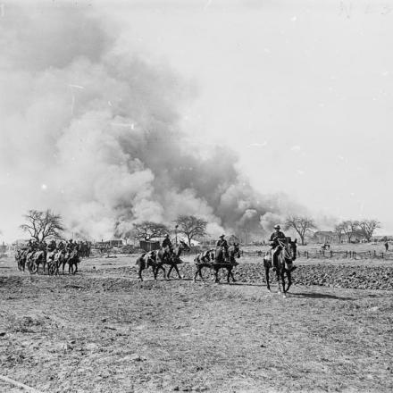 Squadre della Royal Field Artillery che ritiranno i cannoni dalla posizione mentre le capanne e le scorte a Omiecourt vengono bruciate, 24 marzo 1918.© IWM (Q 10797)