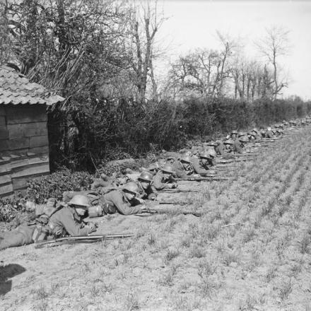 Battaglia di Hazebrouck. Uomini del Reggimento del Royal Warwickshire di fianco al cimitero di Robecq,  aprile 1918. © IWM (Q 6516)