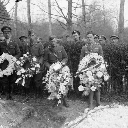 Quattro ufficiali portano sulla tomba le corone degli squadroni di aviazione. Bertangles, 22 aprile 1918. © IWM (Q 10923)