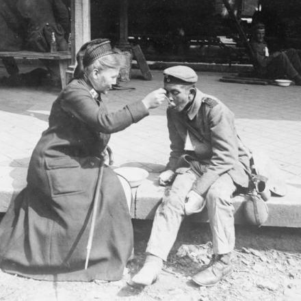 Un soldato tedesco ferito a entrambe le mani, è nutrito da un'infermiera della Croce Rossa. © IWM (Q 55328)