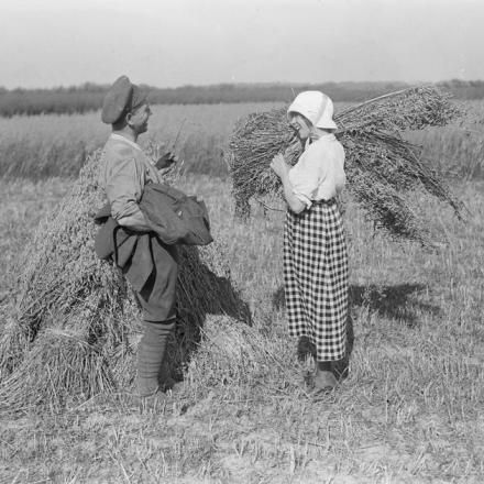 Un soldato dell'Army Service Corps è parla con una ragazza francese mentre la sua unità aiuta nel raccolto, Cayeux, il 13 agosto 1918.© IWM (Q 11228)