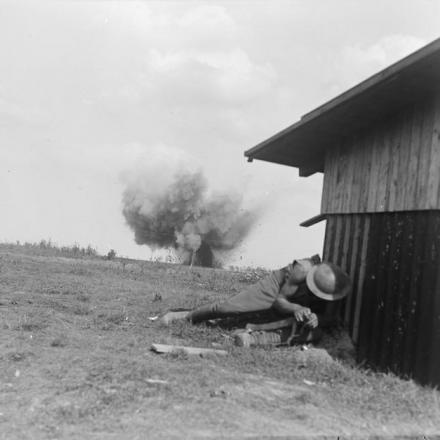 Un soldato della divisione neozelandese cerca riparo dietro una piccola fattoria dalle esplosioni di granate tedesche nelle vicinanze, Grevillers, il 25 agosto 1918. © IWM (Q 11255)