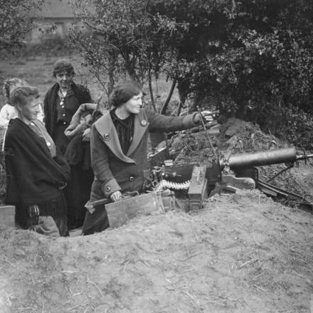 Battaglia di Courtrai. Donne civili belghe che esaminano una mitragliatrice Maxim tedesca che si trovava fuori dal loro cottage. Vicino a Heule, il 15 ottobre 1918. © IWM (Q 7122)