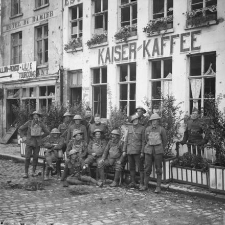 Soldati britannici e belgi al di fuori di una mensa tedesca chiamata "Kaiser Kaffee" (vicino all'Hotel du Damier) a Menin, il 18 ottobre 1918. © IWM (Q 7128)