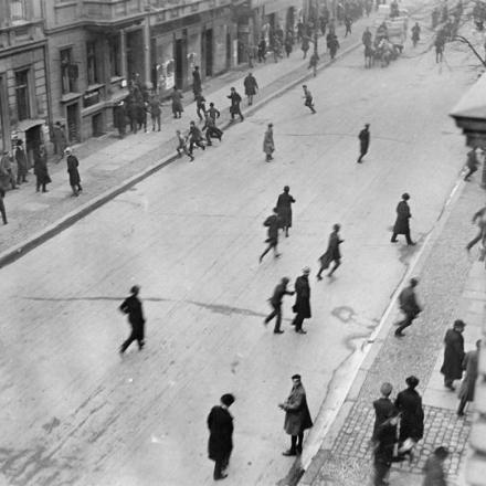 I passanti in strada a Berlino corrono al riparo mentre i rivoluzionari aprono il fuoco. © IWM (Q 110871)