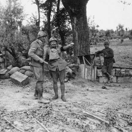 Due ufficiali della brigata italiana "Sassari" conversano mentre le truppe italiane occupano posizioni su una strada, 1918