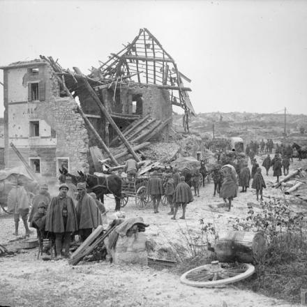 Le truppe italiane con i trasporti di muli attraversano la città in rovina di Asiago. © IWM (Q 25963)