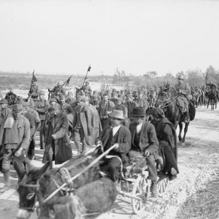Lancieri italiani che scortano prigionieri austro-ungarici lungo la riva del fiume Meduna  attraversato dalle truppe alleate, nel novembre del 1918. © IWM (Q 26731)