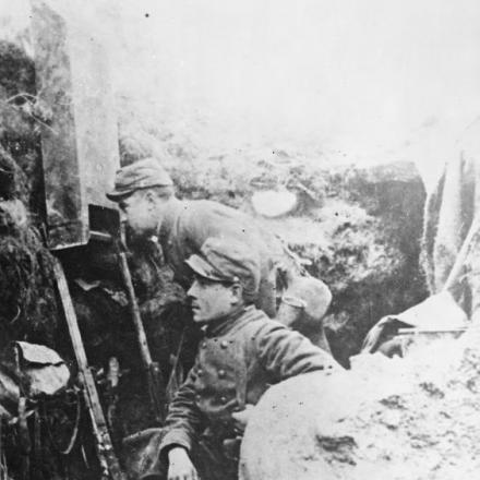 Due soldati francesi in una trincea di prima linea con un periscopio per guardare oltre la sommità.  Argonne, 1915.© IWM Q 53604