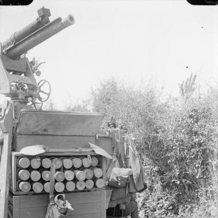Artigliere addormentato sotto un cannone antiaereo da 13 libbre montato su un camion a Hinges, il 18 maggio 1918. © IWM 