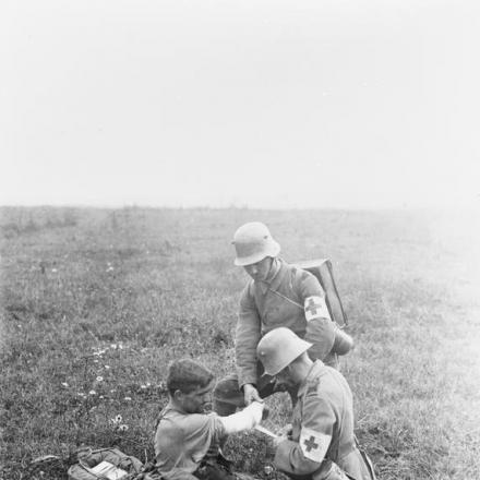 La seconda battaglia della Marna. Inservienti medici tedeschi fasciano la ferita al braccio di un soldato sul campo. Champagne, luglio 1918. © IWM (Q 55374)