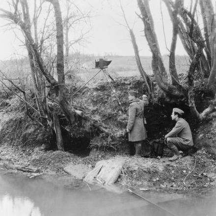 Un fotografo ufficiale americano degli Stati Uniti Signal Corps e il suo assistente effettuano la fotografia di ricognizione sotto la copertura di una profonda sponda del fiume dal fiume Aire sul fronte occidentale, il 6 novembre 1918. La Forge Ferme, 3 chilometri a nord di Varennes-en-Argonne, Meuse.  © IWM (Q 113418)