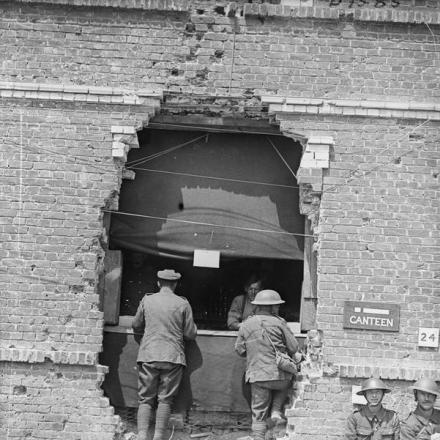 Bancone della mensa della 17a Divisione in un buco nel muro di un edificio bucato da un colpo di cannone. Blangy-sur-Ternoise, 27 giugno 1917.© IWM (Q 5531)